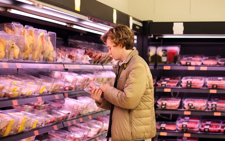 Mann beim Einkaufen von Fleisch in Folienverpackungen