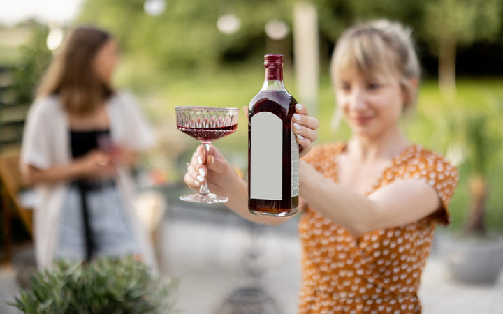 Frau mit einer Alkohol Flasche in der Hand