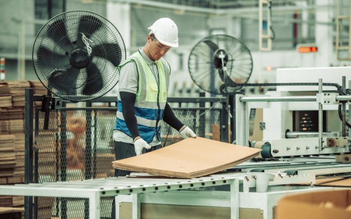 Produktionsmitarbeiter bereitet Karton vor Produktionsmitarbeiter bereitet Karton vor