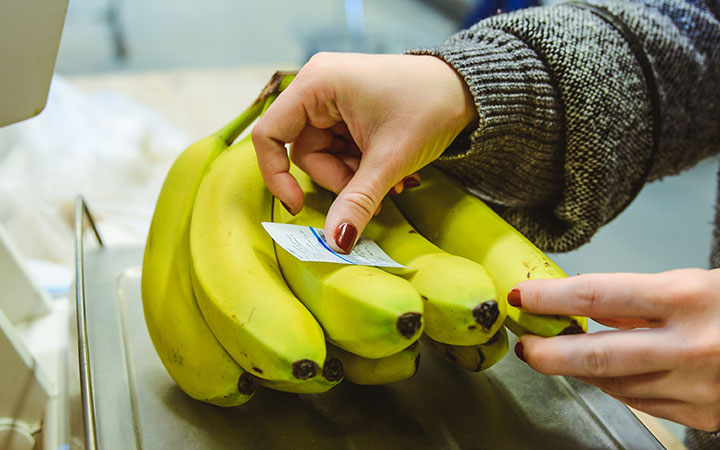 Bananen werden auf der Waage mit Etikett beklebt 